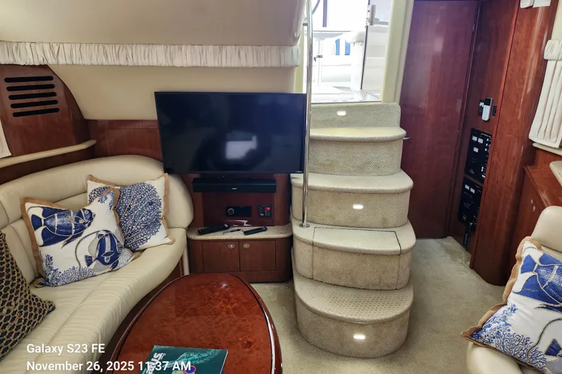 Slide: The Image of 2004 Sea Ray 390 Motor Yacht interior with TV, stairs, and plush seating. - 12