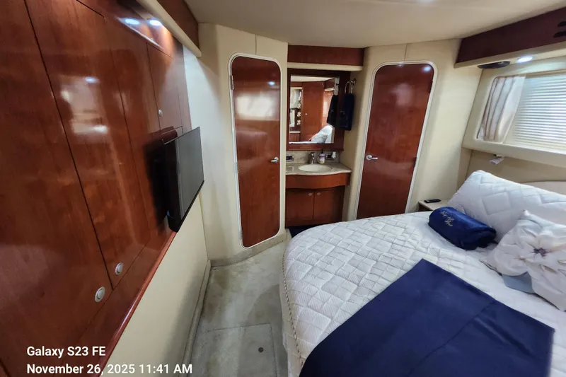 Slide: The Image of Interior of 2004 Sea Ray 390 Motor Yacht with bed, TV, and wooden cabinetry. - 20