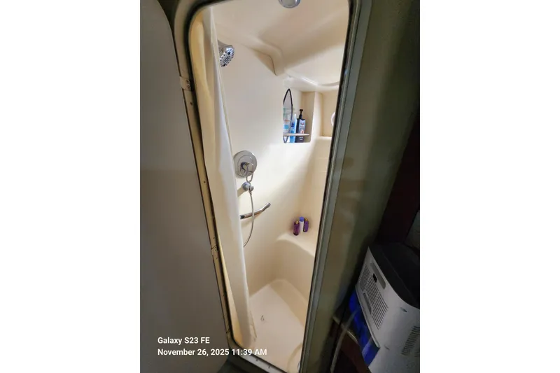 Slide: The Image of Shower area inside 2004 Sea Ray 390 Motor Yacht, featuring toiletries and a curtain. - 23