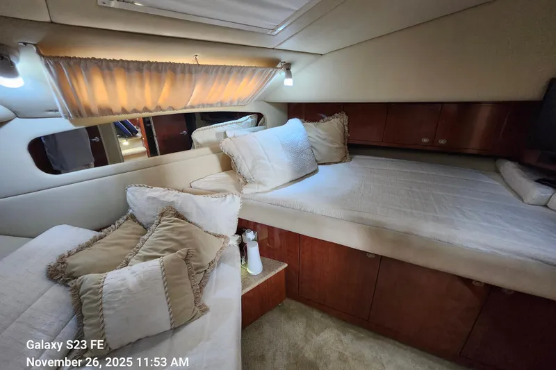 Slide: The Image of Luxurious 2004 Sea Ray 390 Motor Yacht cabin with plush bedding and elegant wood finishes. - 28