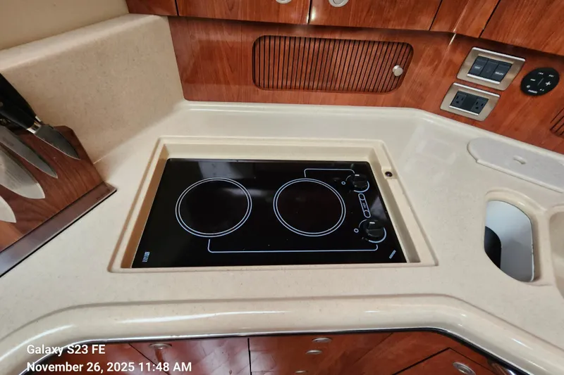 Slide: The Image of 2004 Sea Ray 390 Motor Yacht kitchen with electric stove and wooden cabinetry. - 38