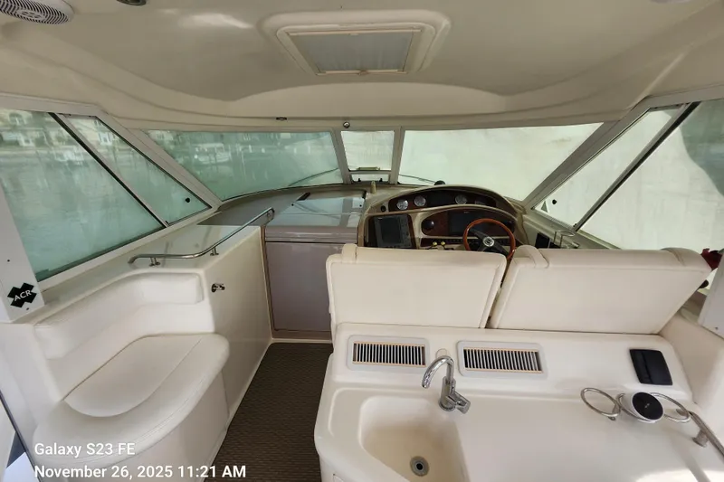 Slide: The Image of 2004 Sea Ray 390 Motor Yacht interior with helm, seating, and sink. - 8