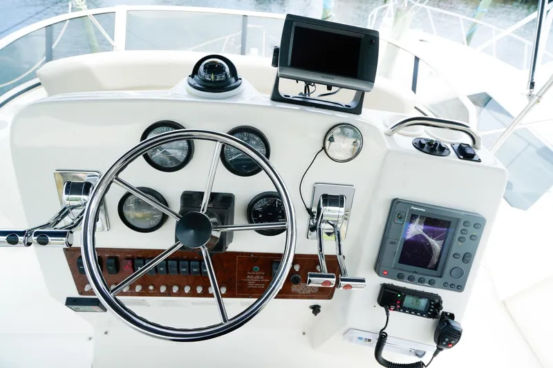 Slide: The Image of 2002 Silverton 352 Motor Yacht helm with steering wheel, gauges, and navigation equipment. - 15
