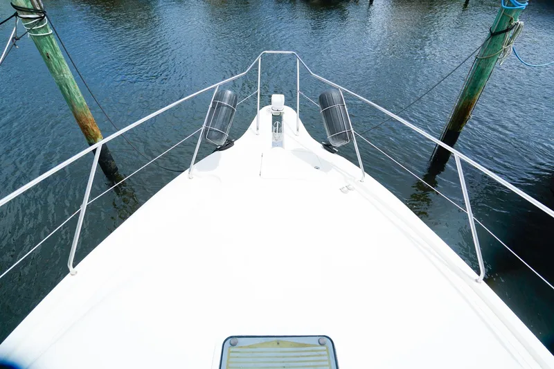 Slide: The Image of 2002 Silverton 352 Motor Yacht bow view at dock, surrounded by calm water. - 23