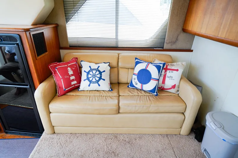 Slide: The Image of Beige sofa with nautical-themed pillows inside a 2002 Silverton 352 Motor Yacht. - 32