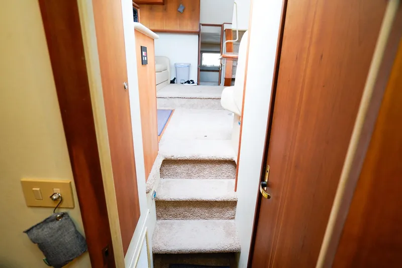 Slide: The Image of Interior view of 2002 Silverton 352 Motor Yacht, featuring carpeted stairs and wooden cabinetry. - 45