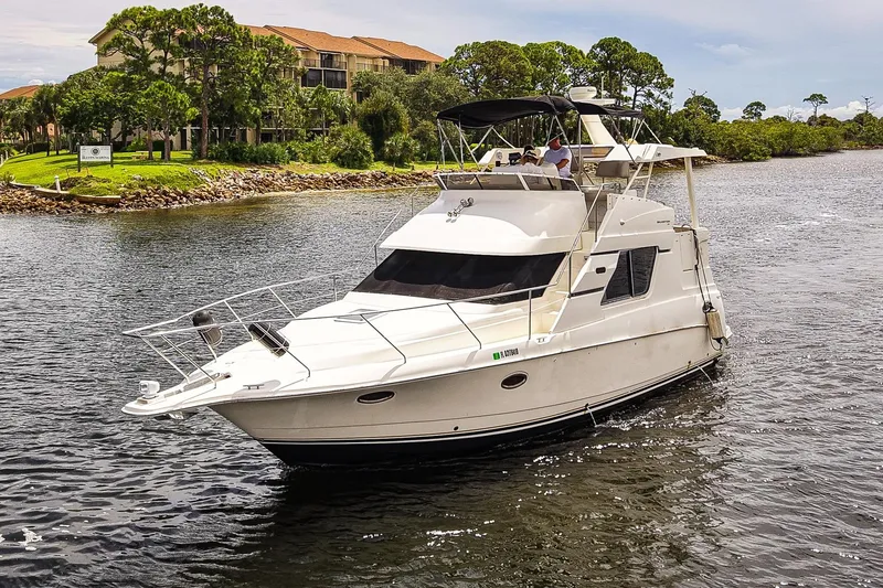 Slide: The Image of 2002 Silverton 352 Motor Yacht cruising on a scenic waterway near lush greenery. - 49