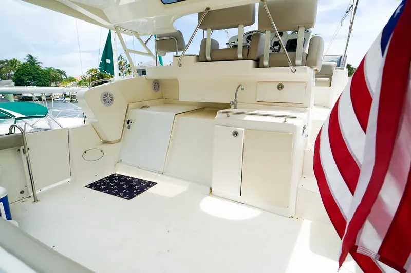 Slide: The Image of 2002 Silverton 352 Motor Yacht deck with seating, sink, and American flag. - 8