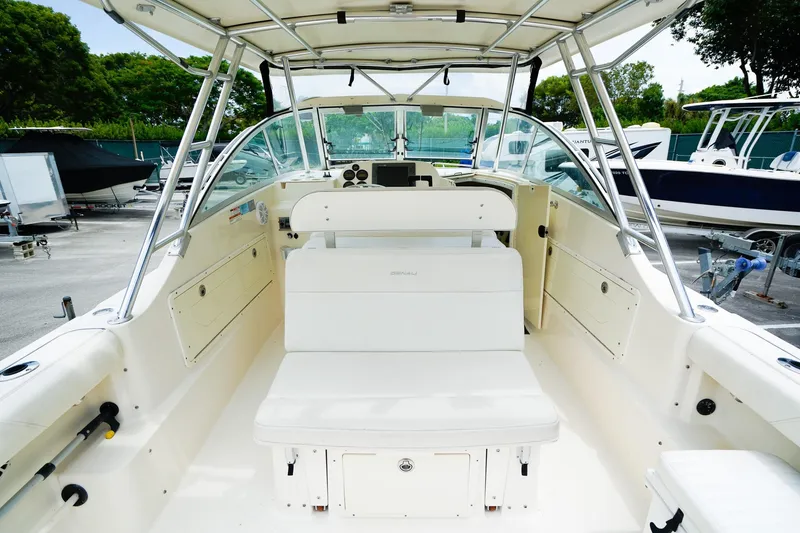 Slide: The Image of 2005 Pursuit 2670 Denali LS boat interior with seating and helm, parked in marina. - 12