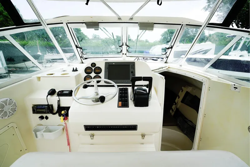 Slide: The Image of 2005 Pursuit 2670 Denali LS boat cockpit with steering wheel and control panel. - 16