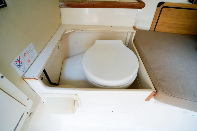 Slide: The Image of 2005 Pursuit 2670 Denali LS boat interior with compact toilet setup. - 20