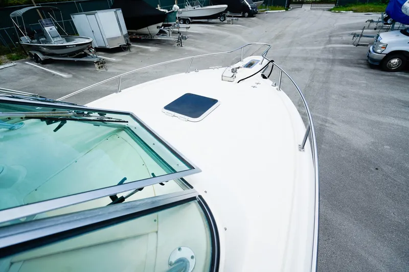 Slide: The Image of 2005 Pursuit 2670 Denali LS boat parked in a marina with other vessels. - 27