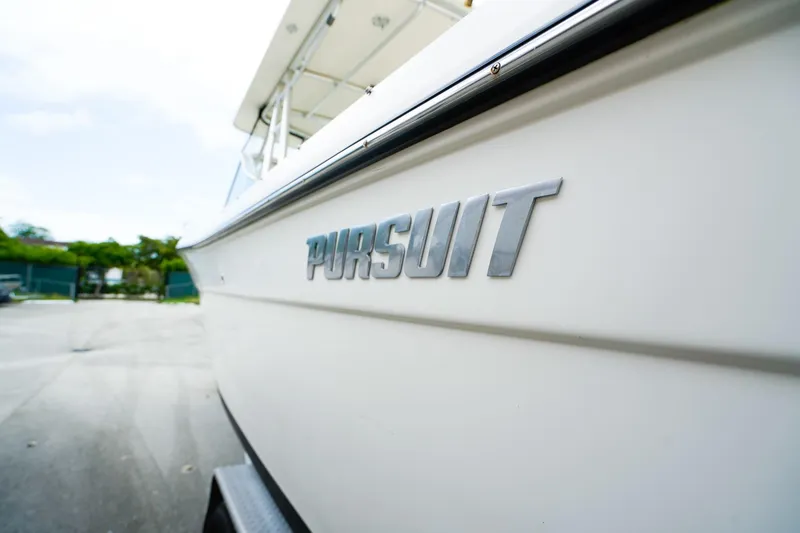 Slide: The Image of 2005 Pursuit 2670 Denali LS boat with logo, parked outdoors. - 28