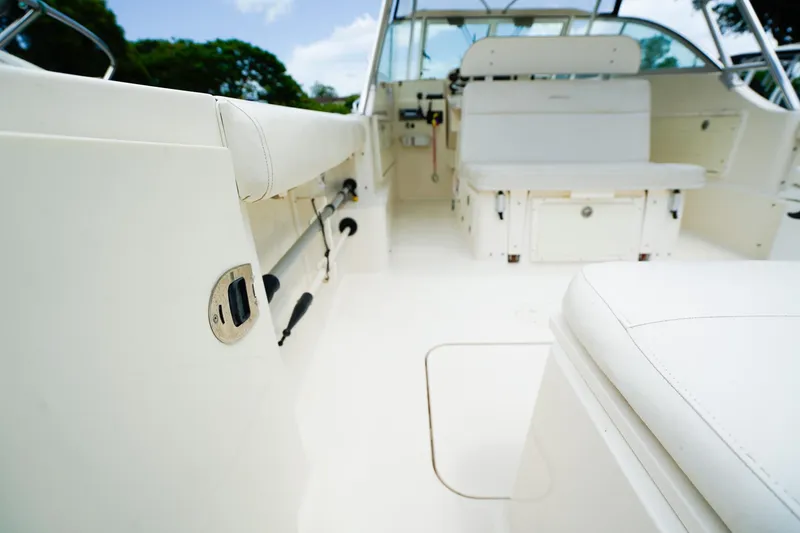 Slide: The Image of 2005 Pursuit 2670 Denali LS boat interior with white seating and storage compartments. - 6