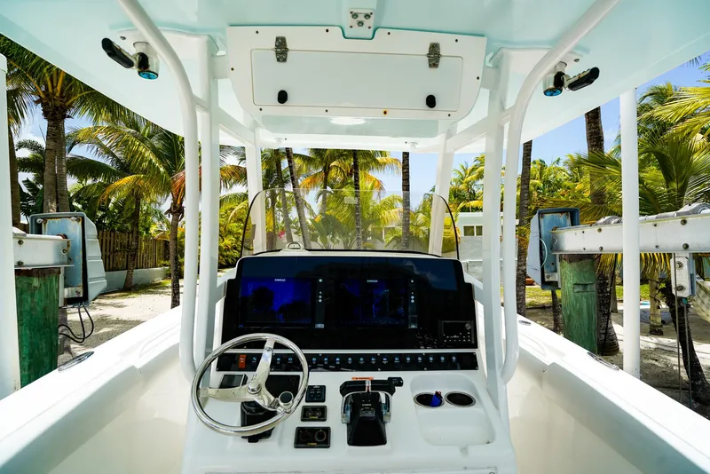 Slide: The Image of 2016 Sea Hunt Gamefish 30 boat dashboard with steering wheel and navigation screens. - 10
