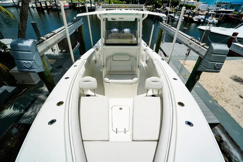 Slide: The Image of 2016 Sea Hunt Gamefish 30 boat interior with white seating, surrounded by palm trees. - 17