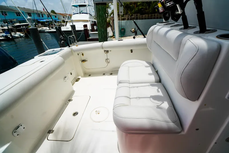 Slide: The Image of 2016 Sea Hunt Gamefish 30 boat with fishing rods, docked near palm trees. - 6