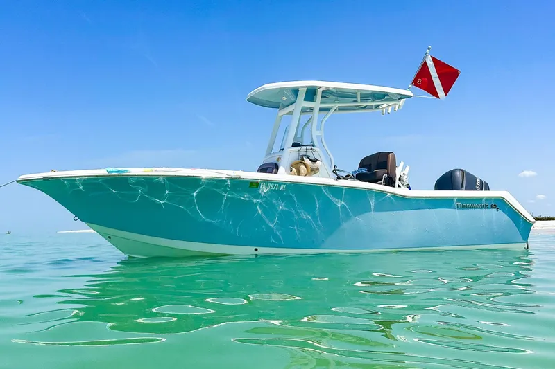 The Image of 2017 Tidewater 230 CC Adventure boat on clear turquoise water under blue sky. - 0