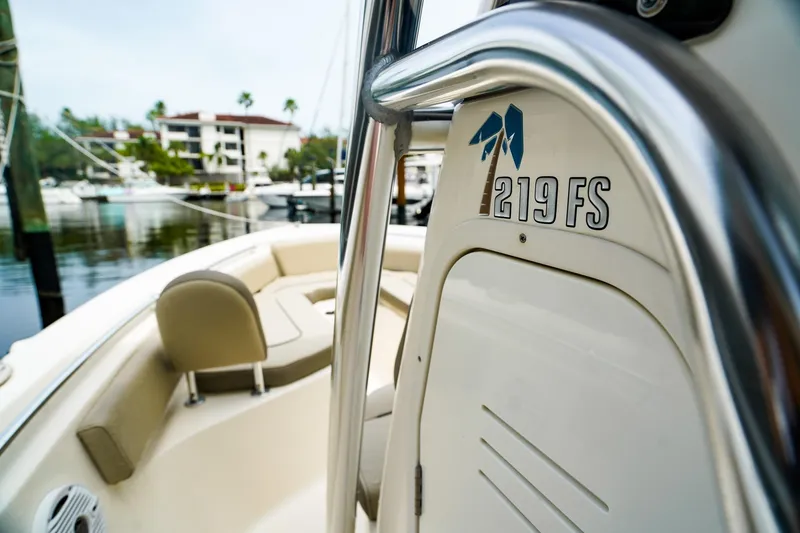 Slide: The Image of 2022 Key West 219 FS boat interior with seating and console, docked at marina. - 17