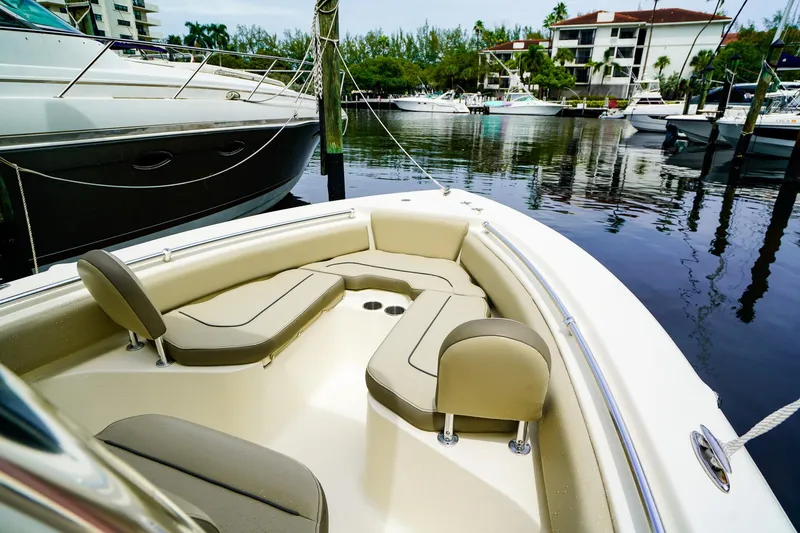 Slide: The Image of 2022 Key West 219 FS boat docked in a marina, featuring comfortable seating and sleek design. - 21