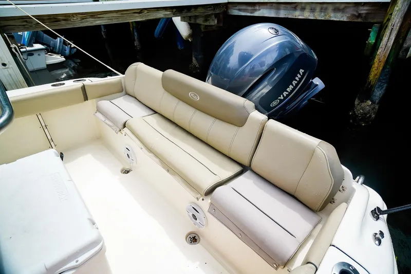 Slide: The Image of 2022 Key West 219 FS boat interior with Yamaha engine, featuring beige seating and storage. - 7