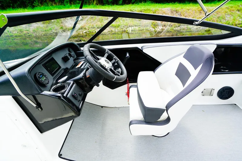Slide: The Image of 2023 Yamaha Boats SX195 cockpit with steering wheel and captain's chair. - 11