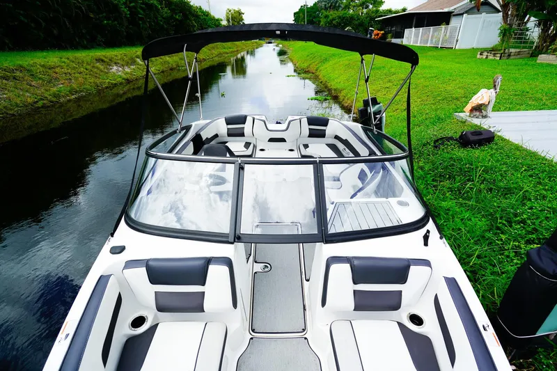 Slide: The Image of 2023 Yamaha Boats SX195 on a serene canal, showcasing sleek design and comfortable seating. - 16