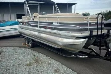 Slide: The Image of 2015 Sun Tracker Party Barge 24 XP3 pontoon boat on trailer in marina setting. - 10