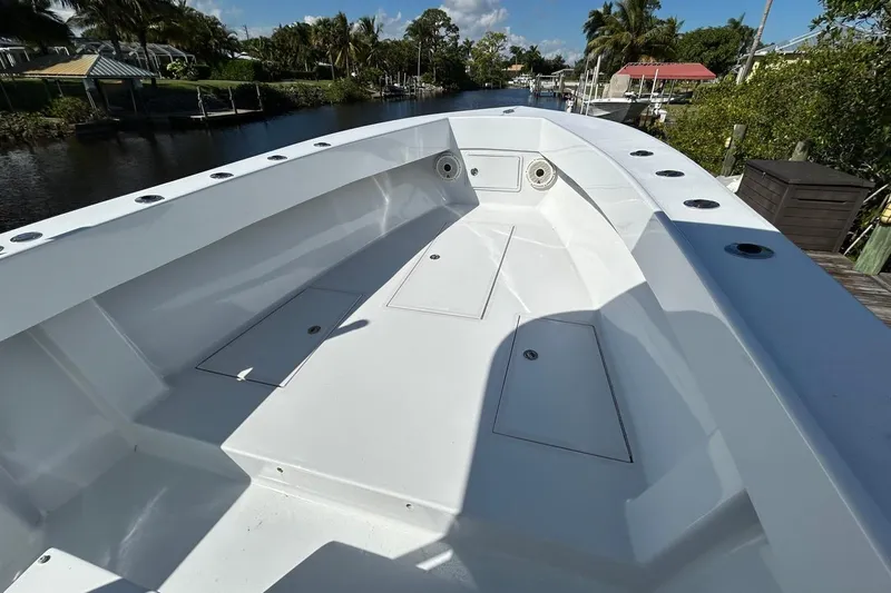 Slide: The Image of 2006 Whitewater 28 boat interior, featuring sleek white deck and storage compartments. - 13