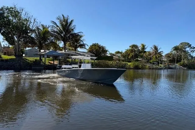 Slide: The Image of 1989 Whitewater 28 boat cruising on a calm river with palm trees in the background. - 30