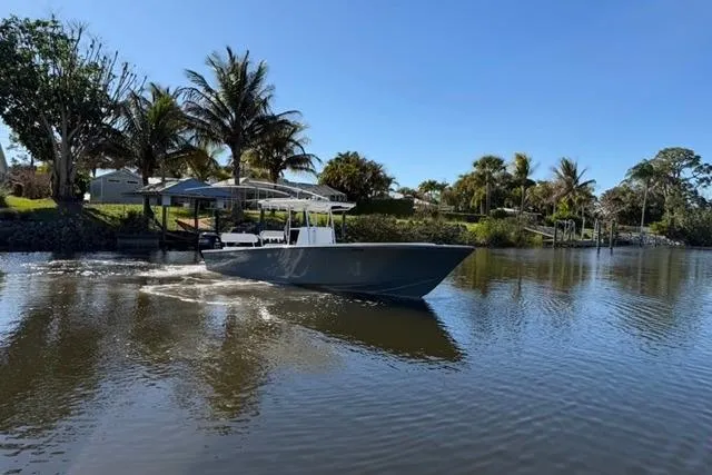 Slide: The Image of 1989 Whitewater 28 boat cruising on a calm river with palm trees in the background. - 31