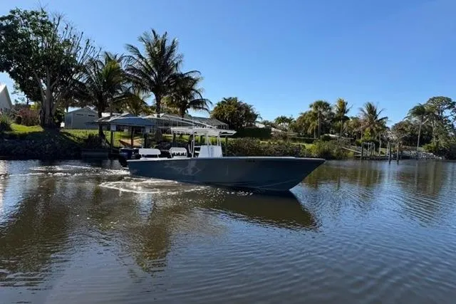 Slide: The Image of 1989 Whitewater 28 boat cruising on a calm river with palm trees in the background. - 32