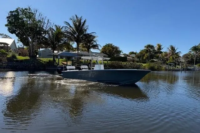 Slide: The Image of 1989 Whitewater 28 boat cruising on a calm river with palm trees in the background. - 33