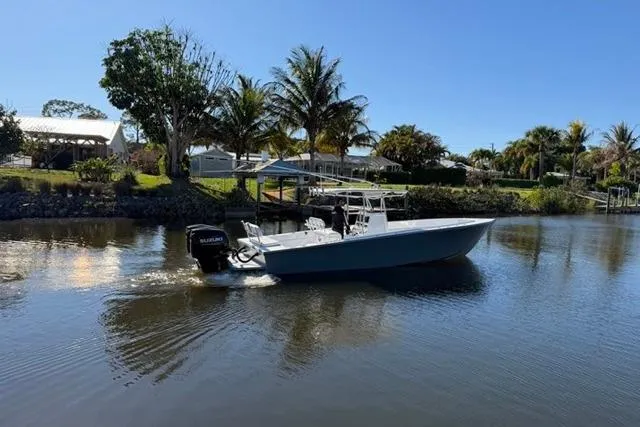 Slide: The Image of 1989 Whitewater 28 boat cruising on a calm river with palm trees in the background. - 35