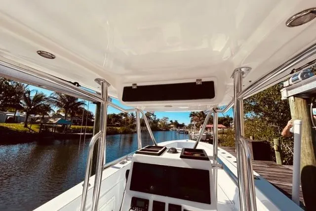 Slide: The Image of 1989 Whitewater 28 boat interior with console, docked by a scenic waterway. - 37
