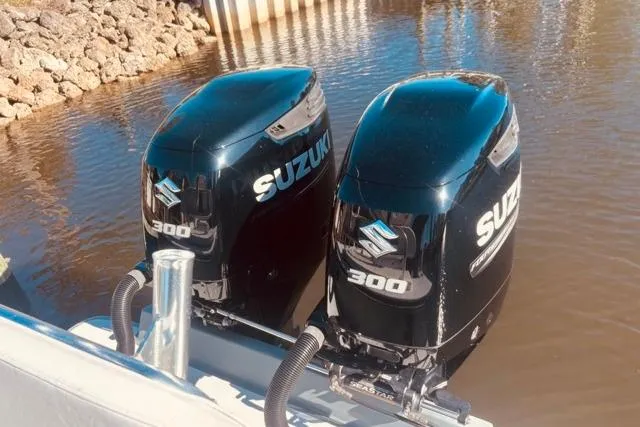 Slide: The Image of Twin Suzuki 300 outboard motors on a 1989 Whitewater 28 boat in calm water. - 41