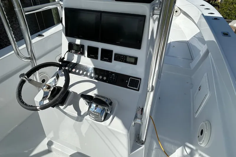 Slide: The Image of 2006 Whitewater 28 boat docked, featuring a spacious deck and modern helm controls. - 5