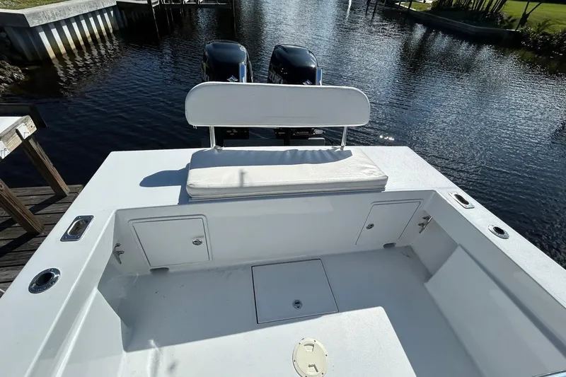 Slide: The Image of 2006 Whitewater 28 boat cockpit with steering wheel and seating, docked by water. - 7