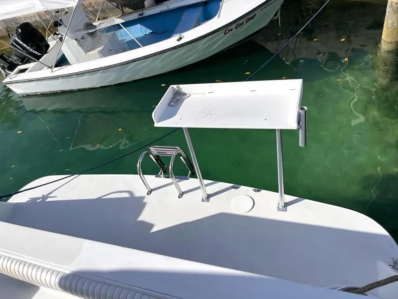 Slide: The Image of 1998 Navigator 53 boat with a white deck and fishing station, docked in clear water. - 11
