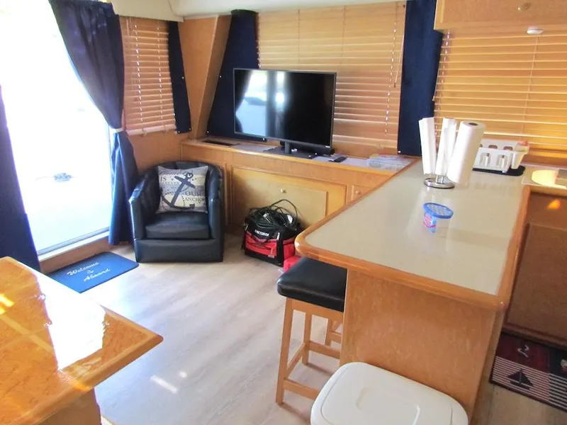 Slide: The Image of Interior of 1998 Navigator 53 yacht with TV, seating, and kitchen area. - 16