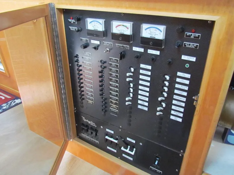 Slide: The Image of Electrical control panel on a 1998 Navigator 53 boat, featuring gauges and switches. - 23