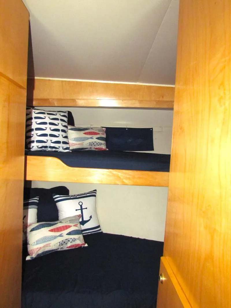 Slide: The Image of Bunk beds with nautical-themed pillows in a 1998 Navigator 53 yacht cabin. - 25