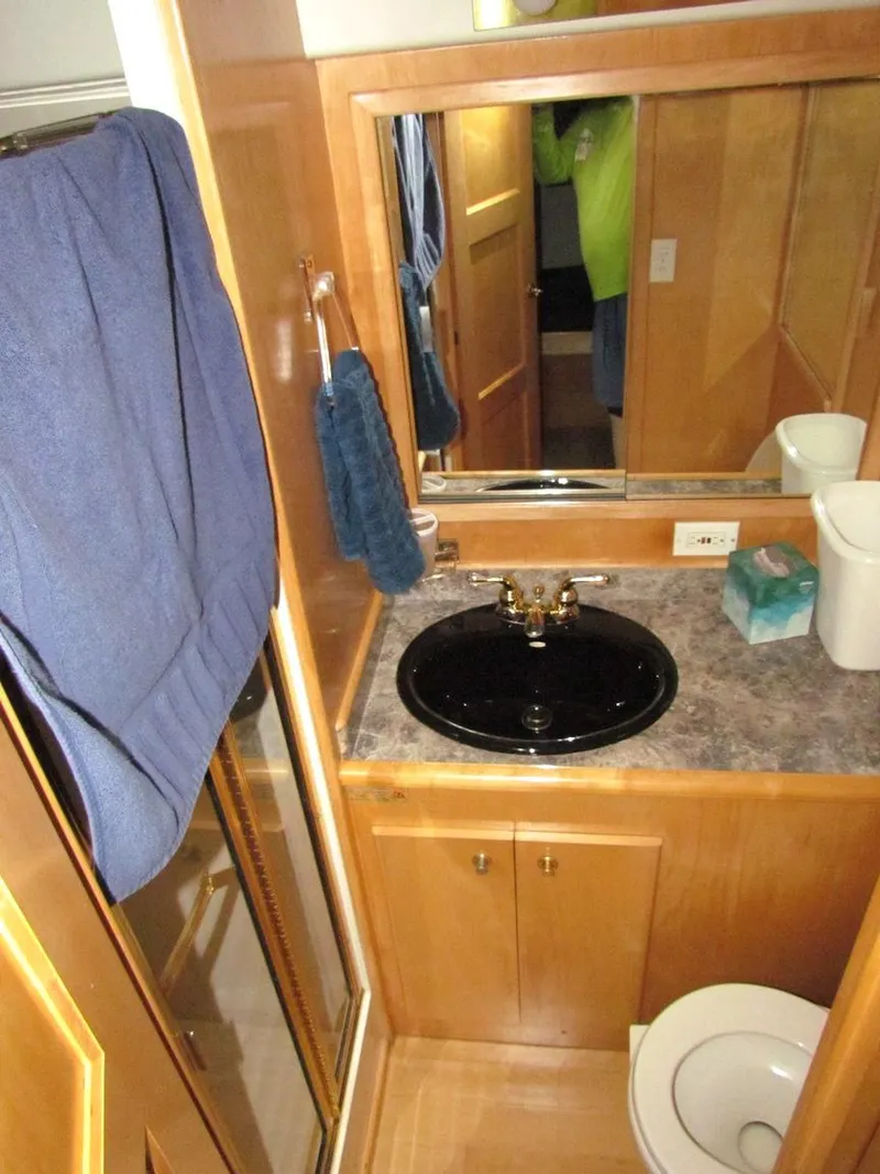 Slide: The Image of Bathroom interior of a 1998 Navigator 53 yacht with wood cabinetry and black sink. - 28