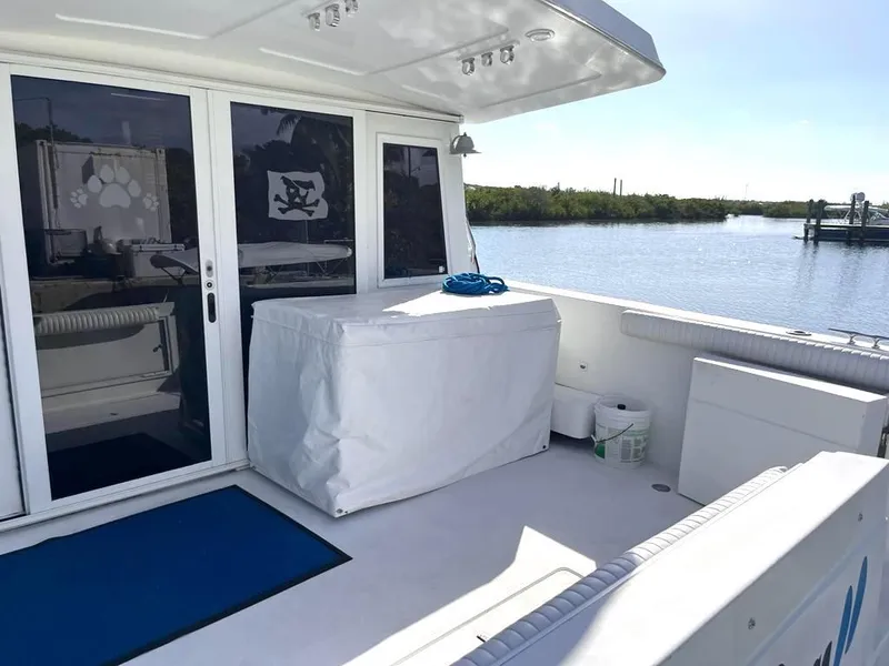 Slide: The Image of 1998 Navigator 53 yacht deck with covered furniture, blue mat, and scenic water view. - 41