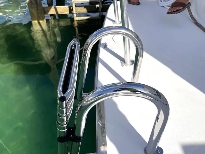 Slide: The Image of Stainless steel boat ladder on 1998 Navigator 53 yacht, docked by clear water. - 7