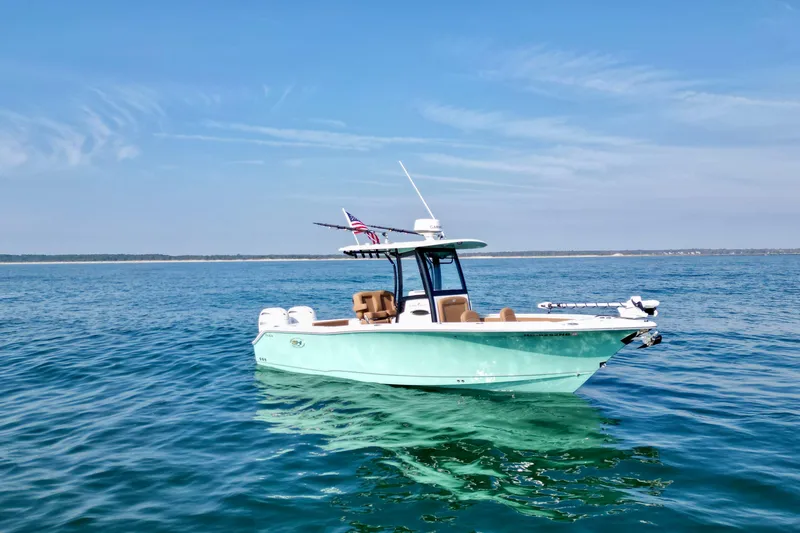 The Image of 2024 Sea Hunt Gamefish 25 boat on calm ocean waters under clear blue sky. - 1
