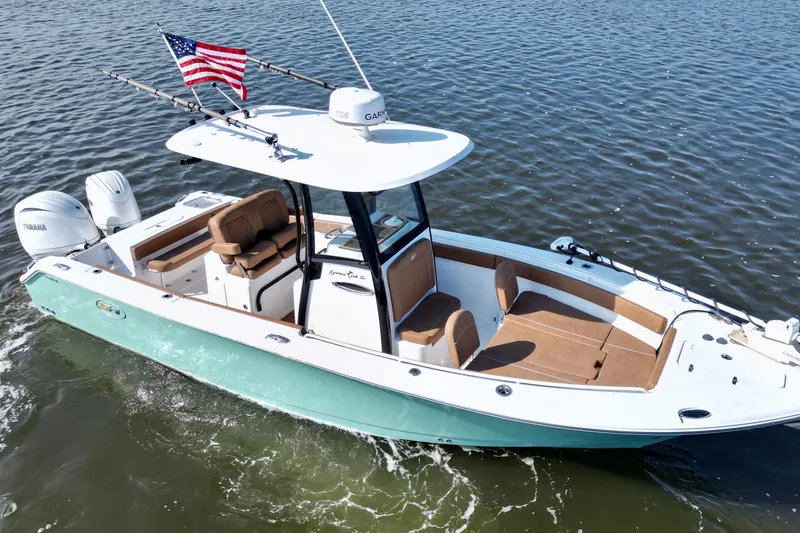Slide: The Image of 2024 Sea Hunt Gamefish 25 boat on water with American flag and Yamaha engines. - 15