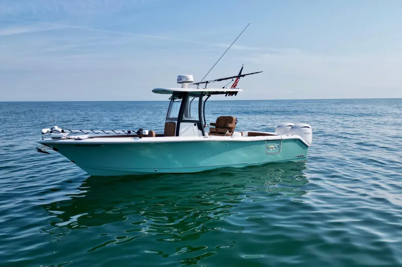 Slide: The Image of 2024 Sea Hunt Gamefish 25 boat on calm ocean waters under clear sky. - 4