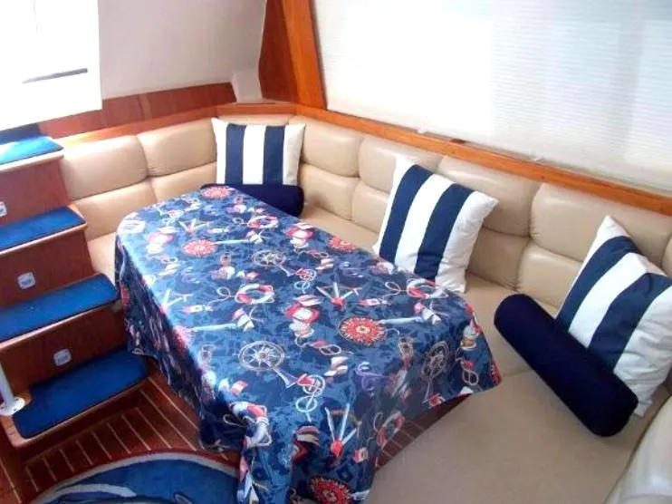 Slide: The Image of Mainship 430 Trawler 2000 interior with nautical-themed tablecloth and striped cushions. - 15