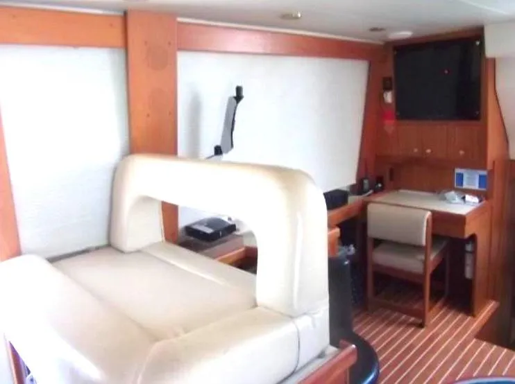 Slide: The Image of Interior of 2000 Mainship 430 Trawler with seating, desk, and mounted TV. - 9